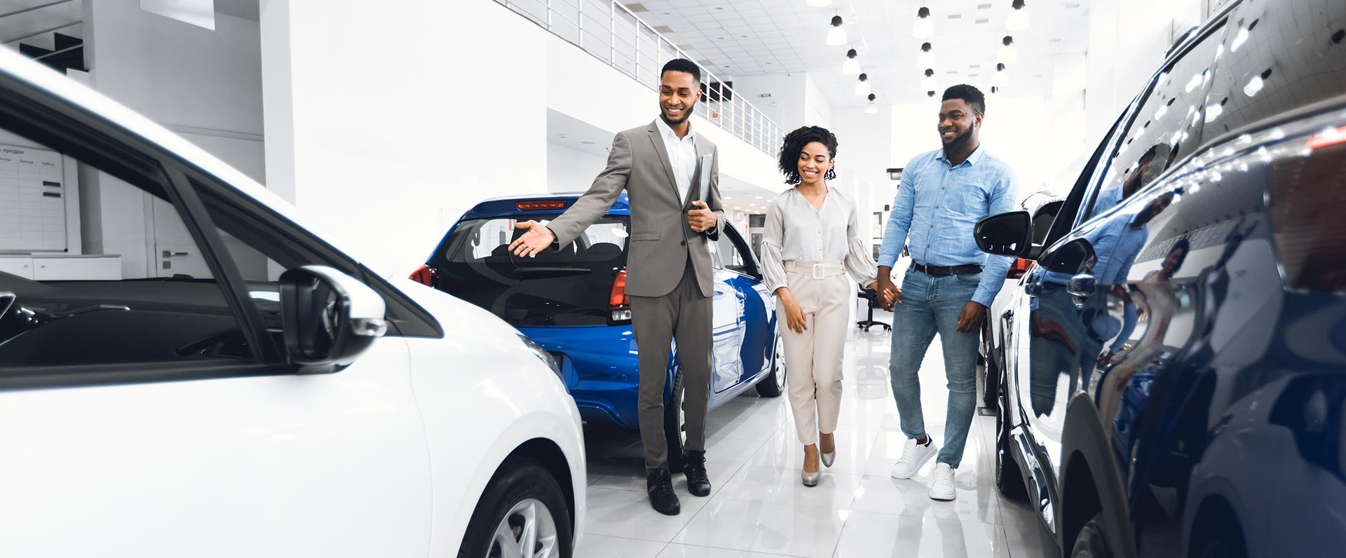 Customer couple with sales person in car showroom
